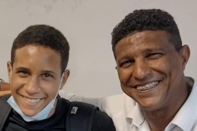 Imagem mostra dois homens sorrindo, abraçados