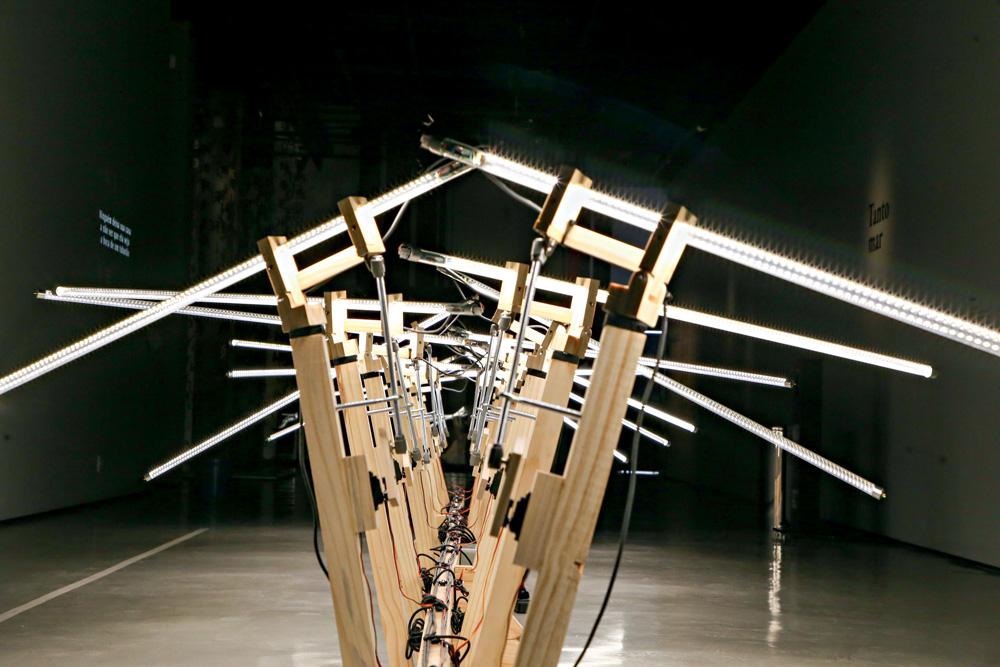 Imagem mostra estrutura de madeira que eleva diversos bastões de luz, enfileirados.