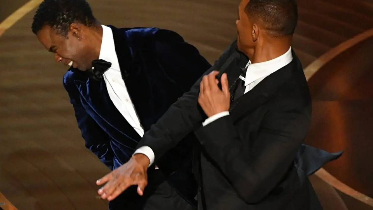 A imagem mostra Will Smith dando um tapa em Chris Rock