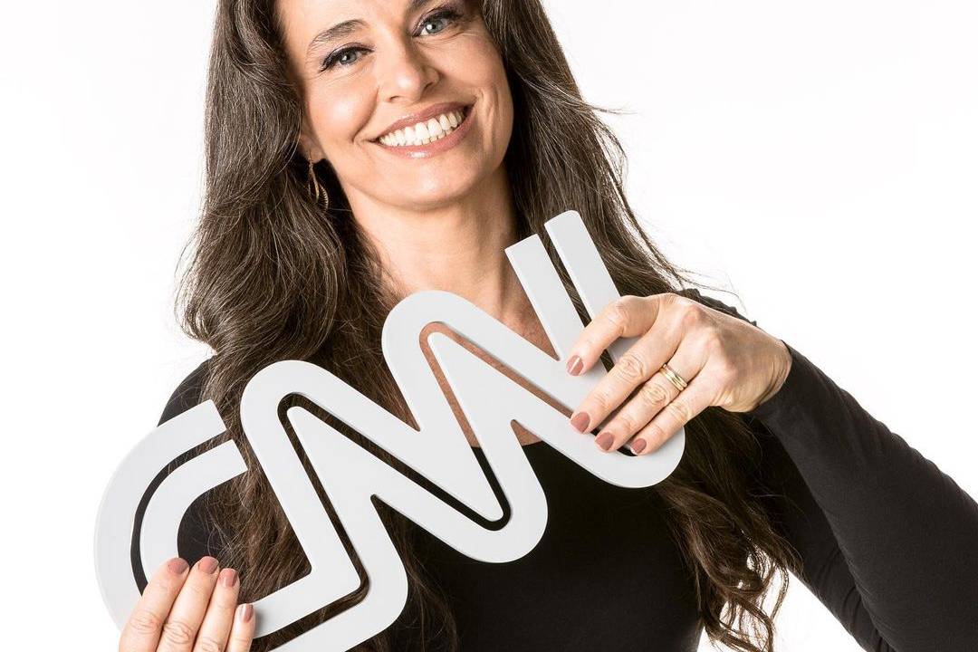A jornalista Carla Vilhena segura placa da CNN Brasil
