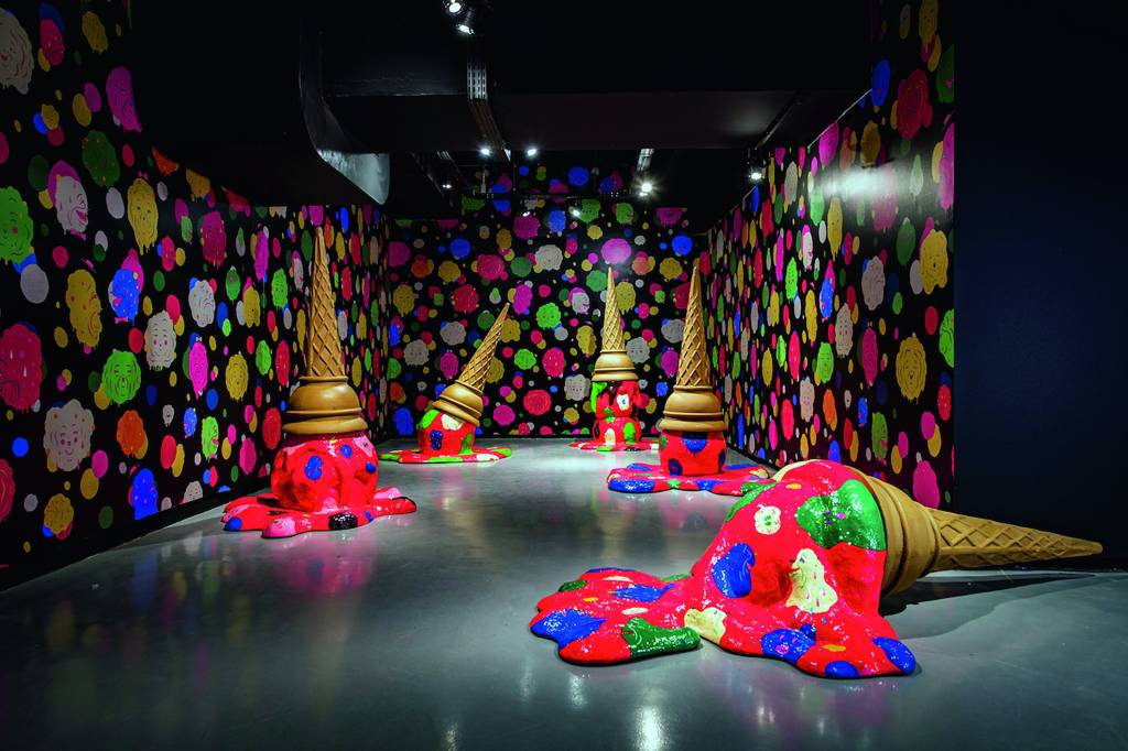 Imagem mostra sala com cinco esculturas de sorvetes derretidos, coloridos.