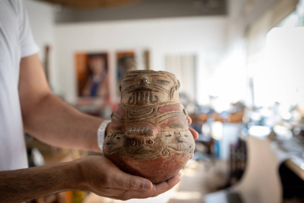 Imagem mostra Noel segurando cerâmica indígena antiga, desgastada pelo tempo. Item é uma espécie de jarro com desenhos talhados