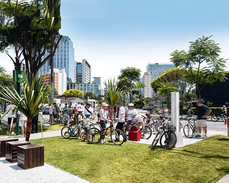 Imagem mostra praça com gramado e diversas bicicletas.