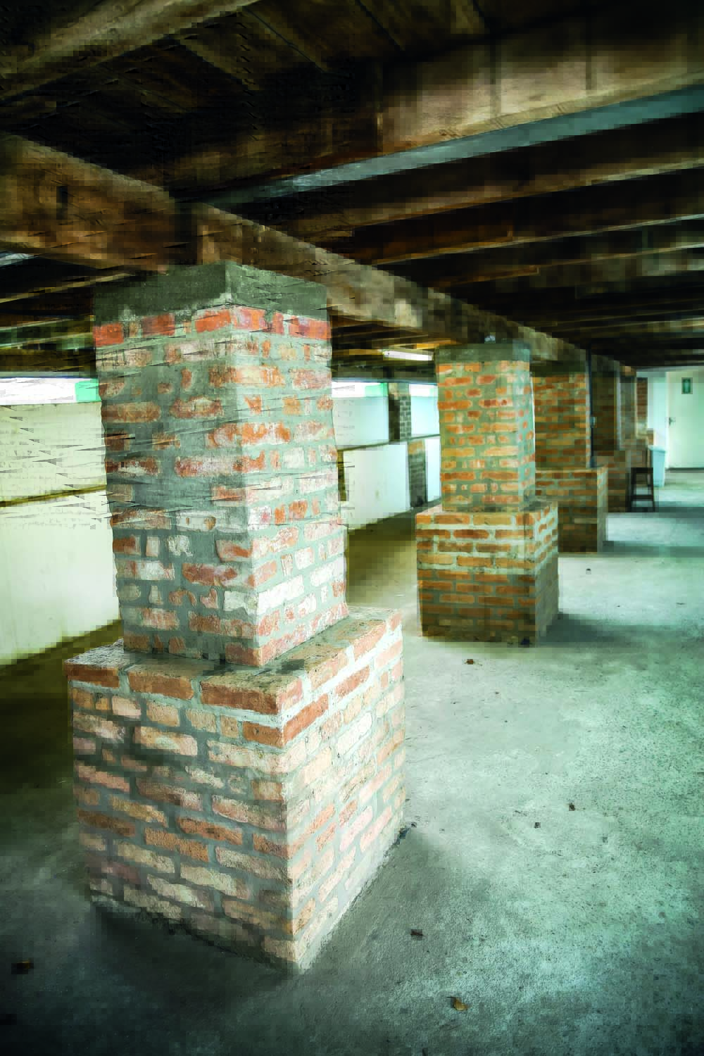 Imagem mostra corredor com diversos pilares de tijolos.