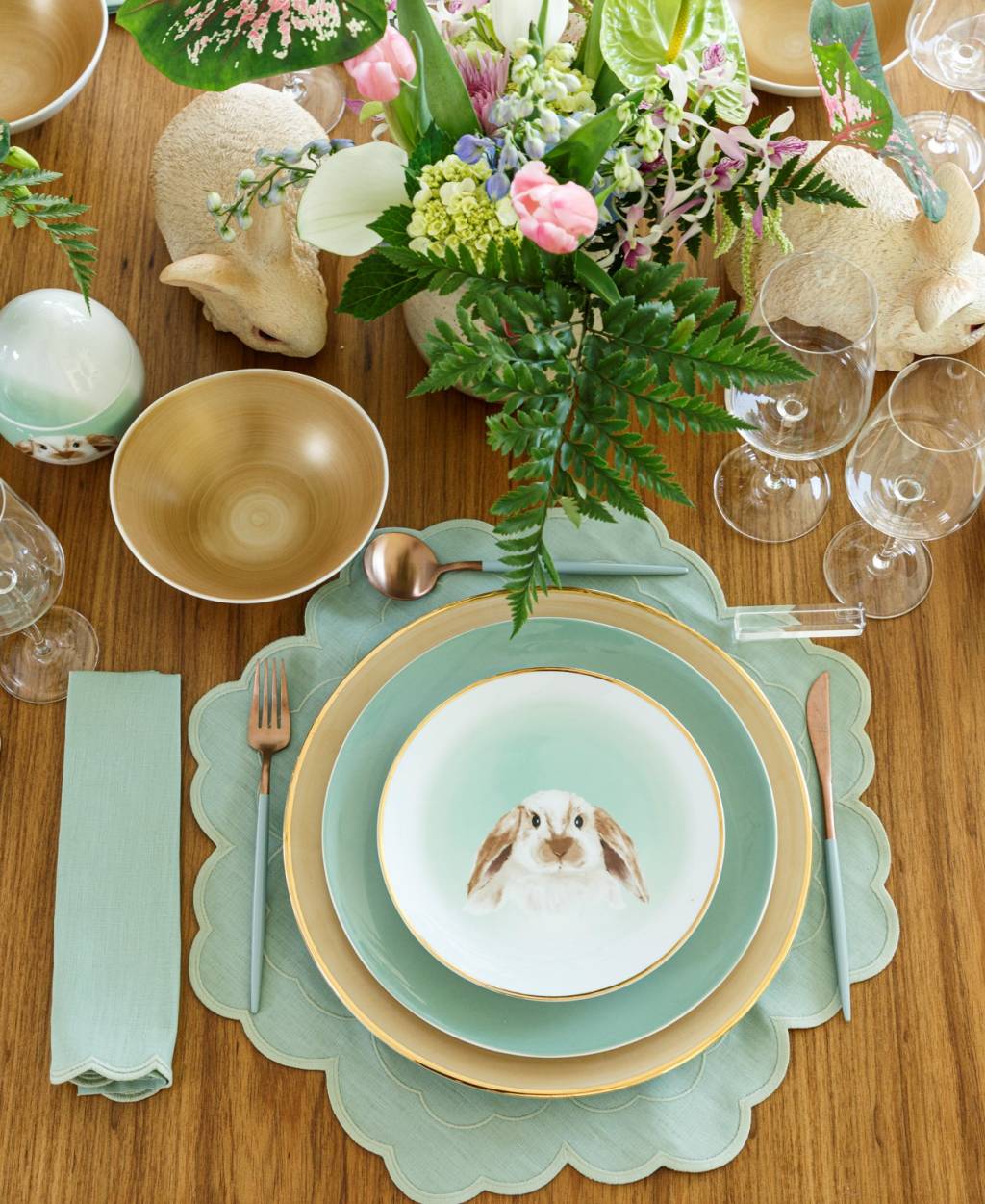 Foto exibe prato com figura de coelho no centro e vaso na mesa.