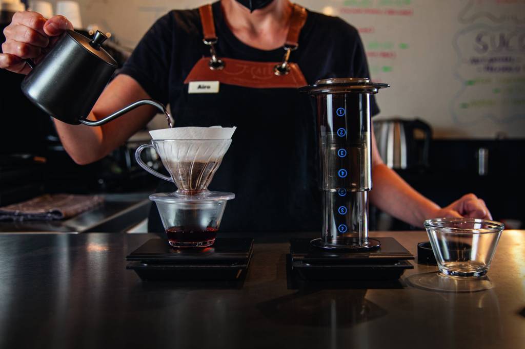 Atendente prepara o café coado na Hario V60