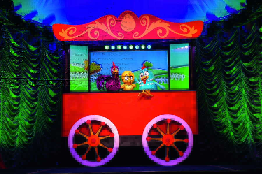 Um carrinho vermelho com três fantoches de personagens da Galinha Pintadinha em cima