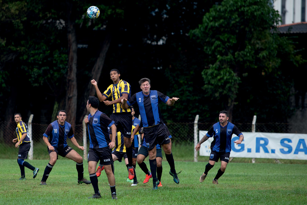 Time de futebol com uniformes joga em um campo gramado