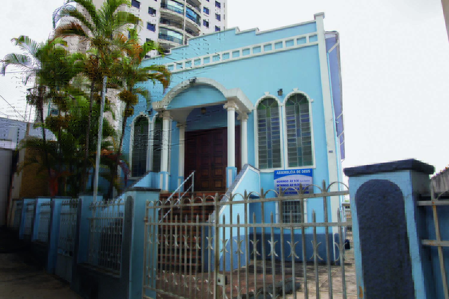 Imagem mostra casa com paredes azuis e detalhes brancos.
