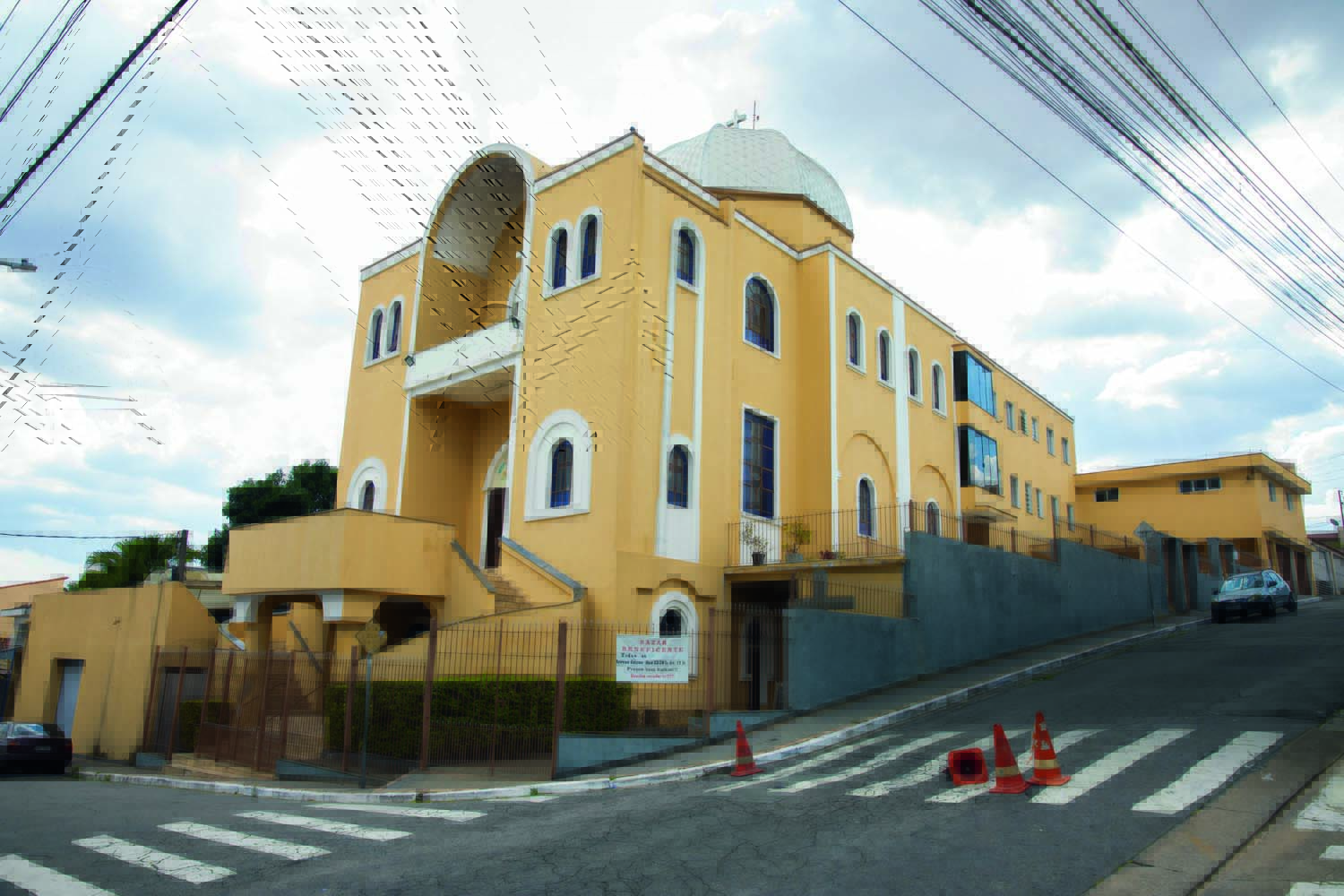 Imagem mostra fachada de igreja com paredes amarelas, em esquina de duas ruas.