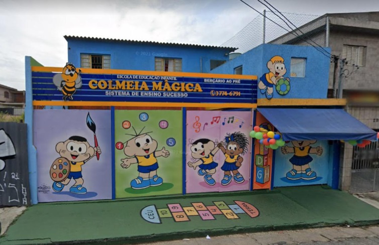 Imagem mostra fachada da escola, pintada com desenhos infantis