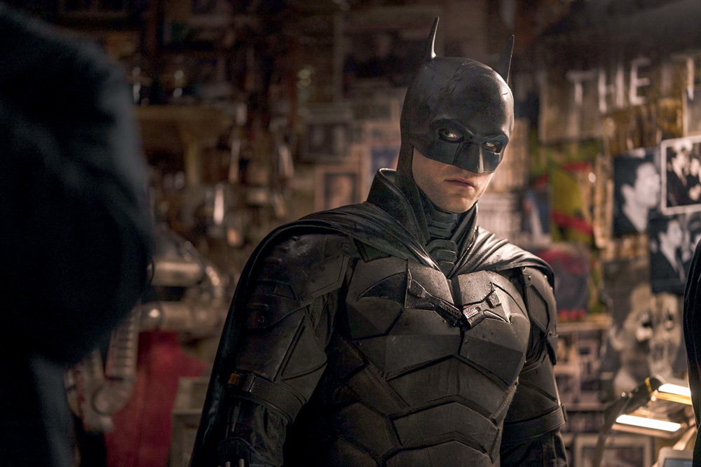 Imagem mostra homem vestido de Batman - com armadura preta com símbolo de morcego ao centro, além de uma máscara preta que cobre todo o rosto, menos o queixo.