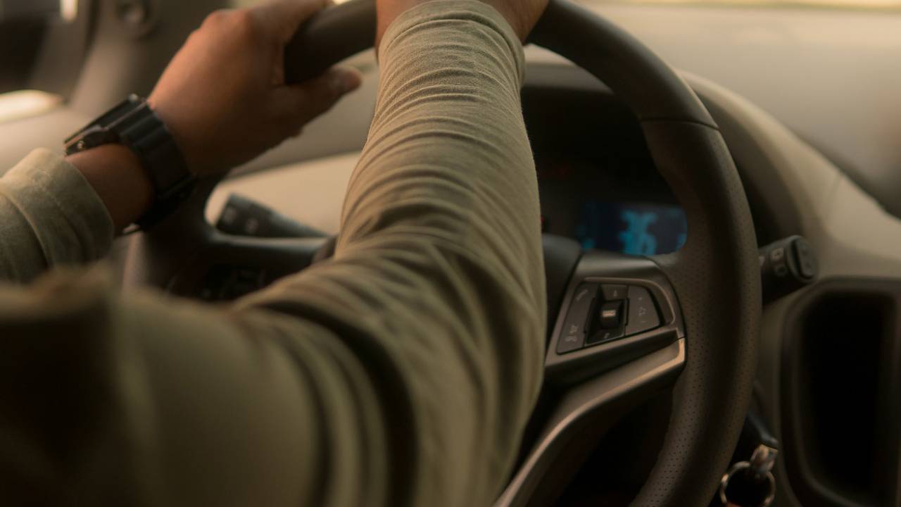 Imagem mostra homem dirigindo carro