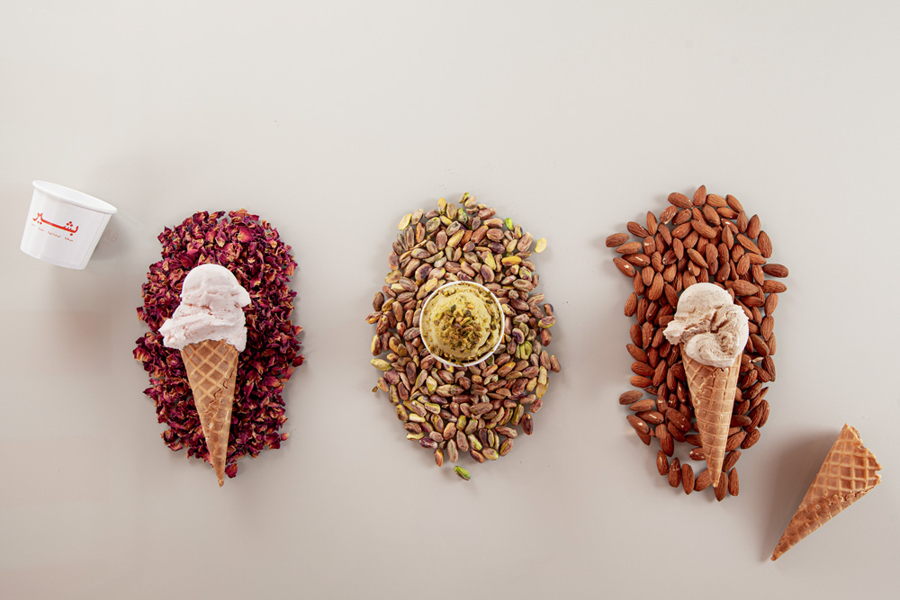 Três sorvetes de diferentes sabores dispostos sobre um fundo de cor neutra