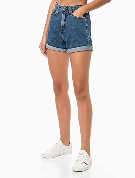 modelo branca e magra usa short jeans e tênis branco