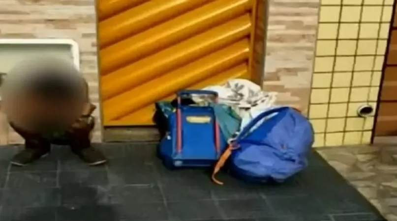 Imagem mostra malas de viagens dispostas no chão, ao lado de uma criança com a imagem borrada