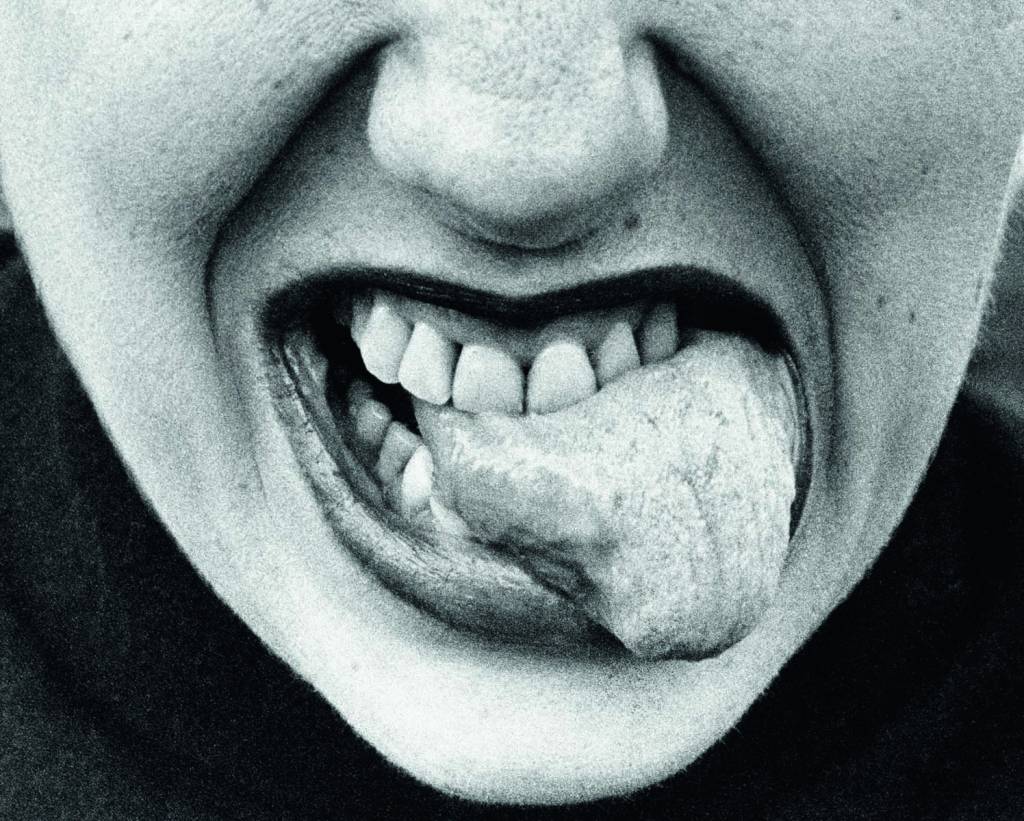 51943181127_bf4514372c_o.jpg Imagem mostra boca de mulher com os dentes mordendo a própria língua.