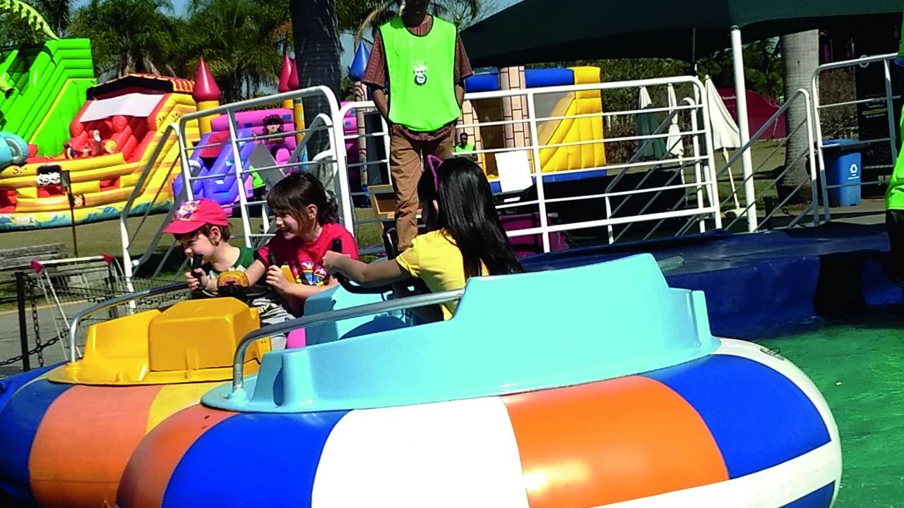 Crianças brincam em dois jet boats, barcos coloridos que flutuam em uma piscina, em um dia ensolarado no Parque Villa-Lobos