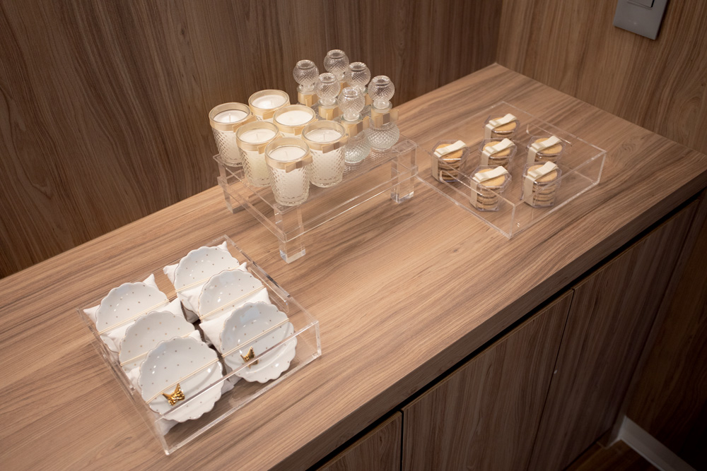 Mesa com pratos brancos, copos e biscoitos em recipientes transparentes
