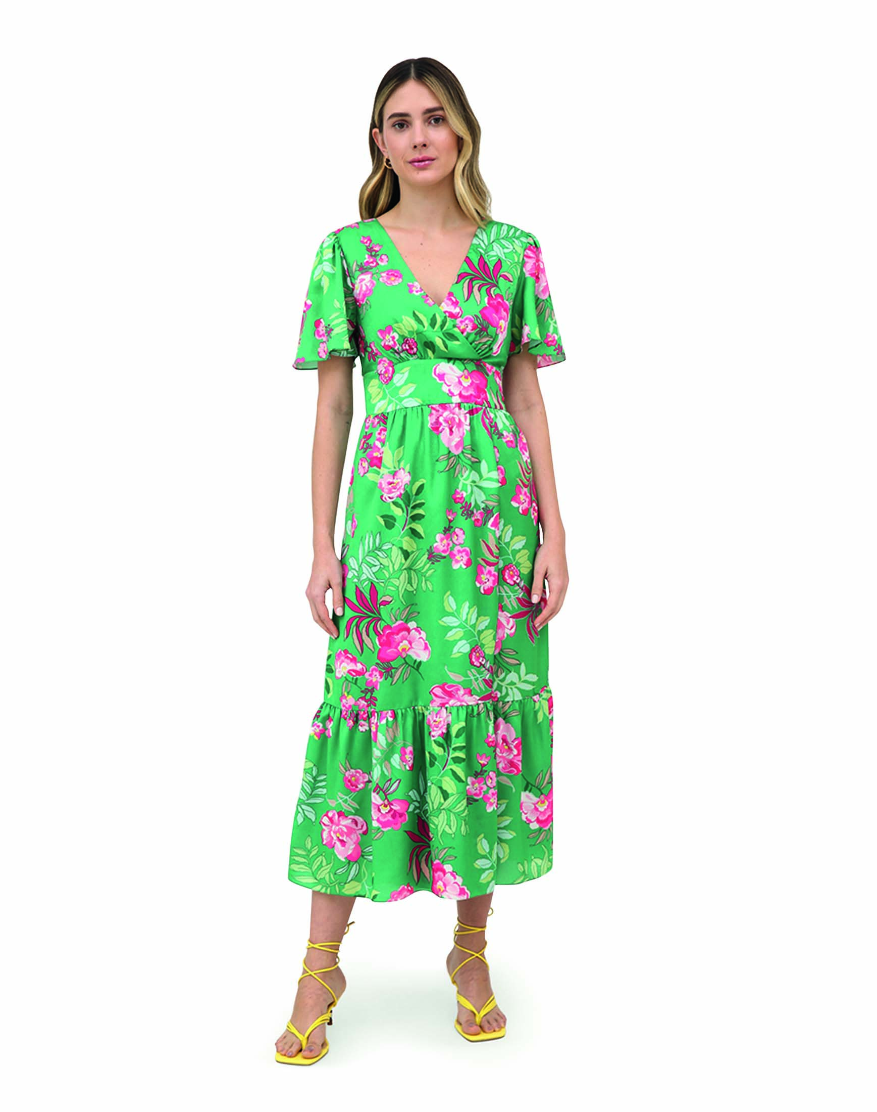 Modelo branca, magra e loira usa vestido longo com estampa floral verde e rosa