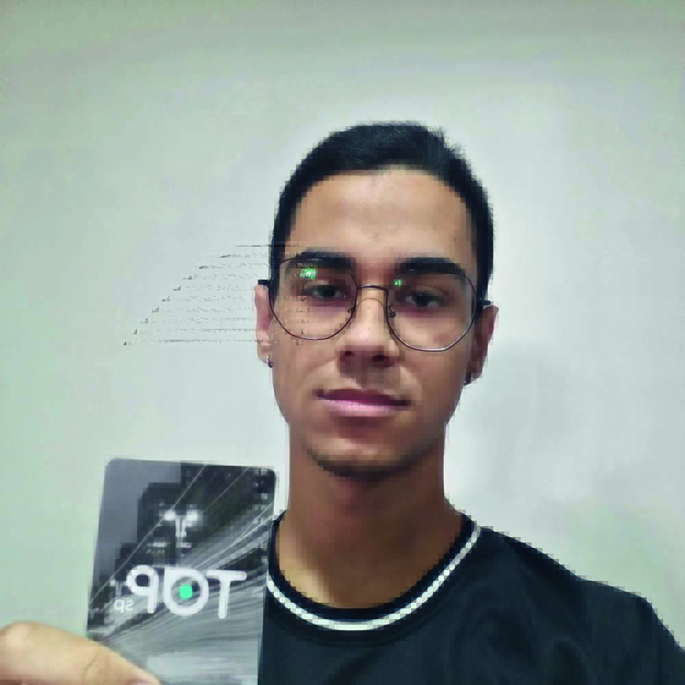 WhatsApp Image 2022-04-22 at 14.50.20.jpg João Vitor Sousa aparece de óculos e camiseta preta segurando seu cartão TOP com a mão