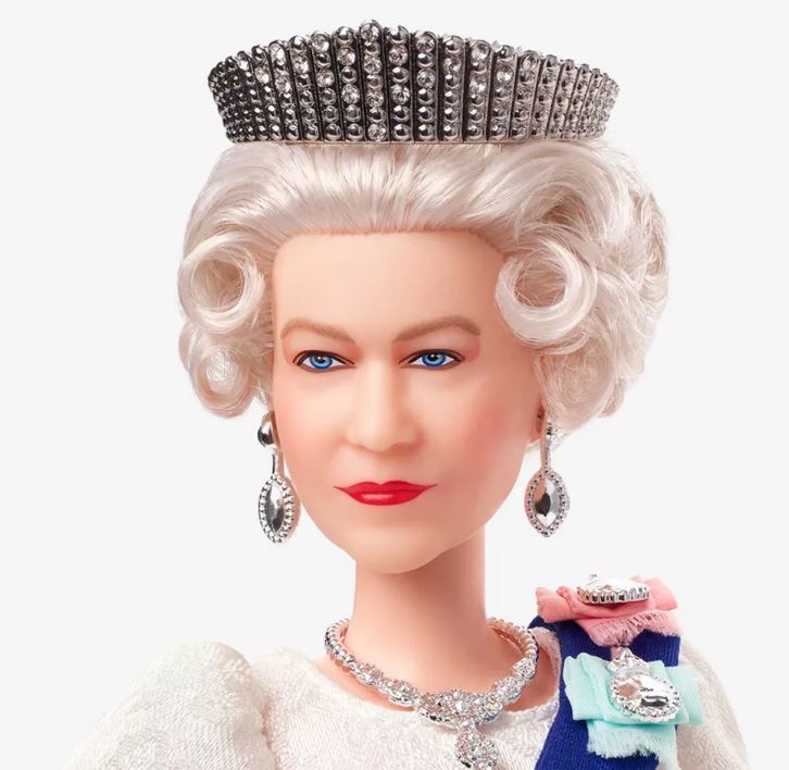 imagem da boneca da rainha. ela usa coroa, brincos e colar