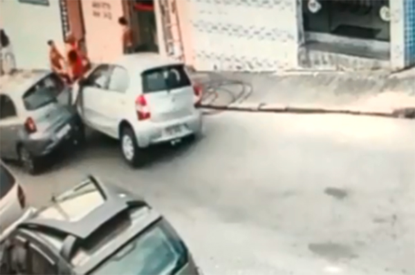 Imagem mostra carro colidindo contra a traseira de outro em rua de descida