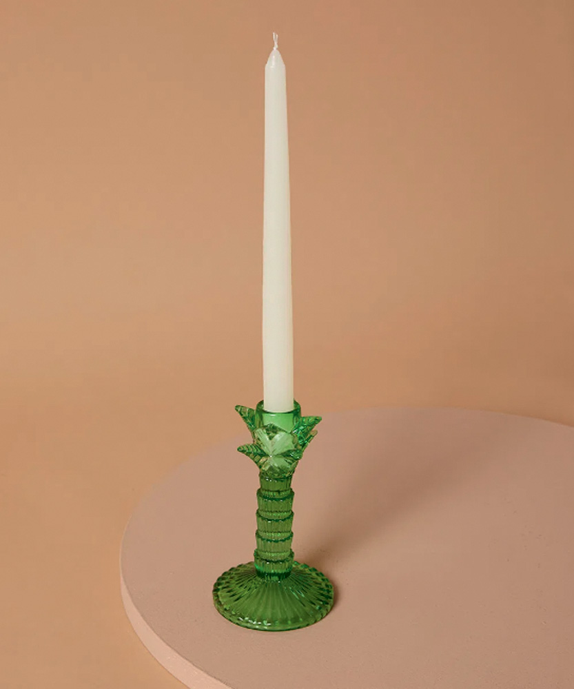 Castiçal verde de vidro com uma vela branca comprida