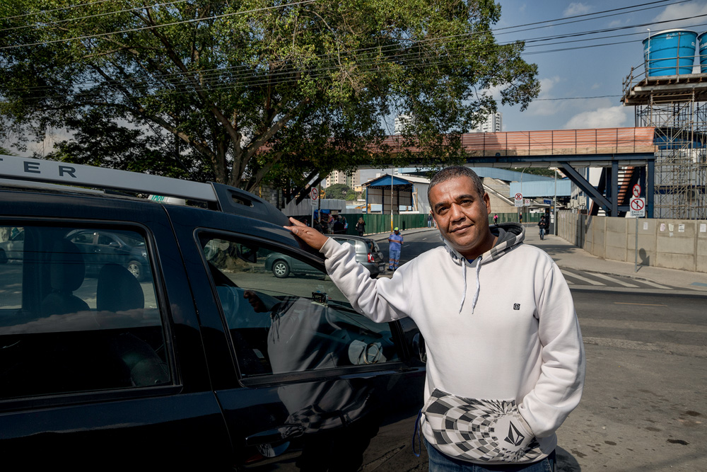 Taxista Reinaldo ao lado de seu carro
