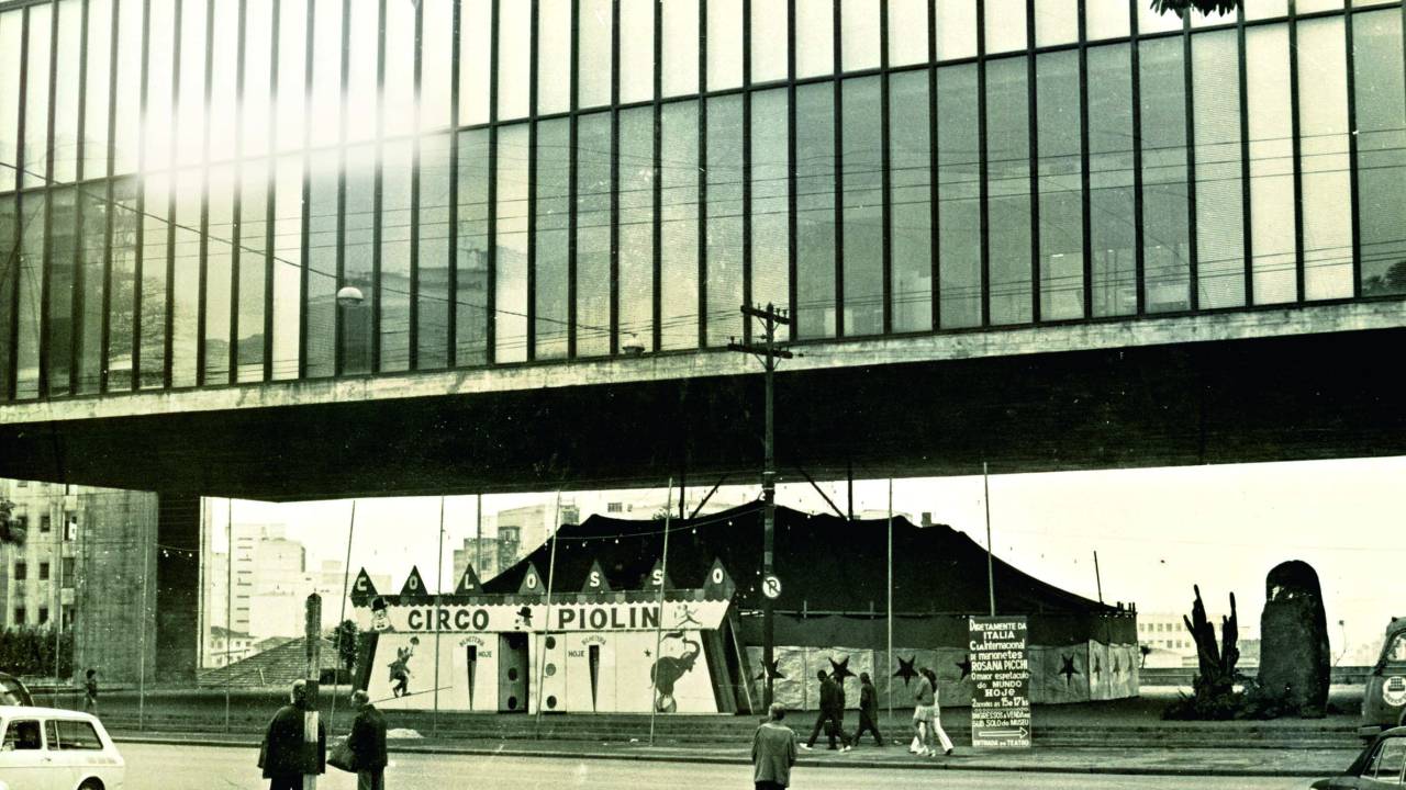 Imagem em preto e branco mostra circo montado em vão de prédio .