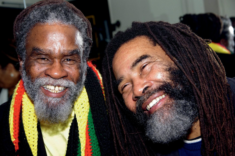 Imagem mostra dois homens de barba grisalha sorrindo.