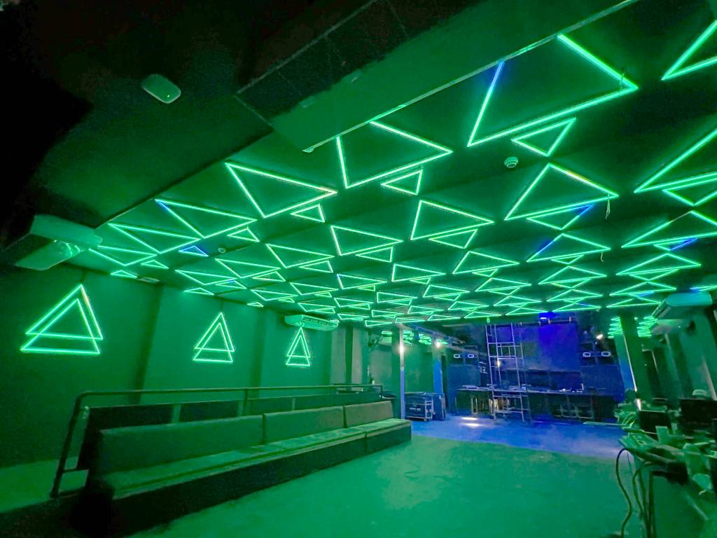 Imagem mostra espaço iluminado por luzes neon verdes