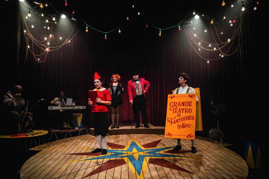 Em um palco montado como um picadeiro de um circo do início do século XX, atores interpretam Pinóquio e outros personagens de época
