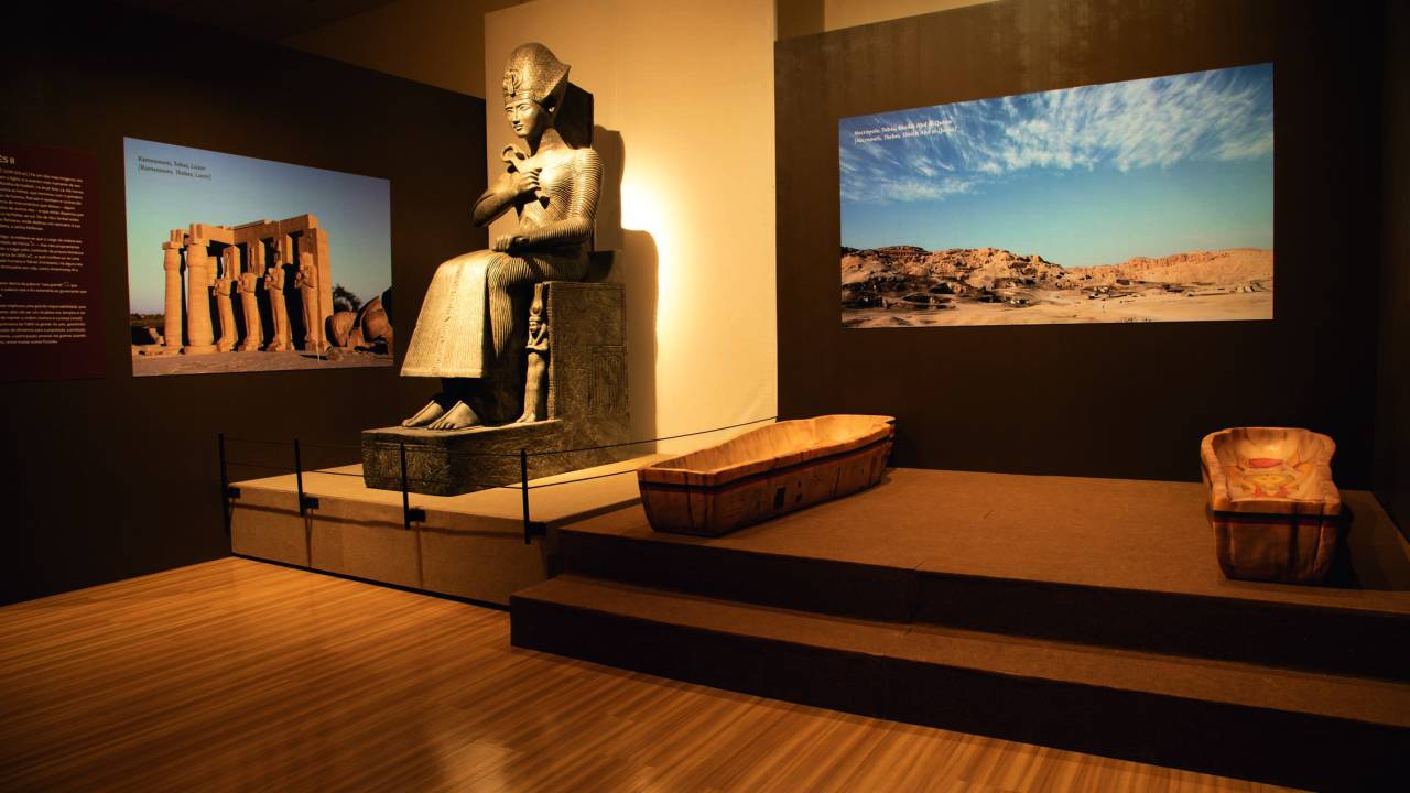 Imagem mostra sala com estátua de faraó e representação de sarcófago ao lado