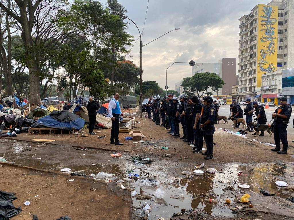 A foto mostra fileira de policiais em meio a lixo na nova Cracolândia, na Praça Princesa Isabel