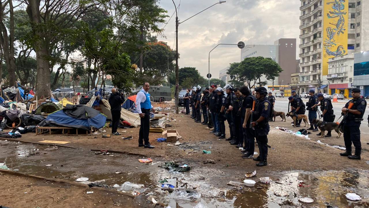 A foto mostra fileira de policiais em meio a lixo na nova Cracolândia, na Praça Princesa Isabel