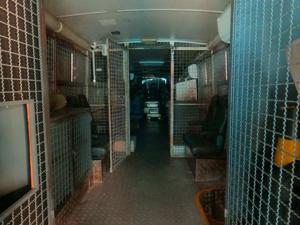 Foto mostra interior de um ônibus cenográfico escuro, com aparência de assombrado
