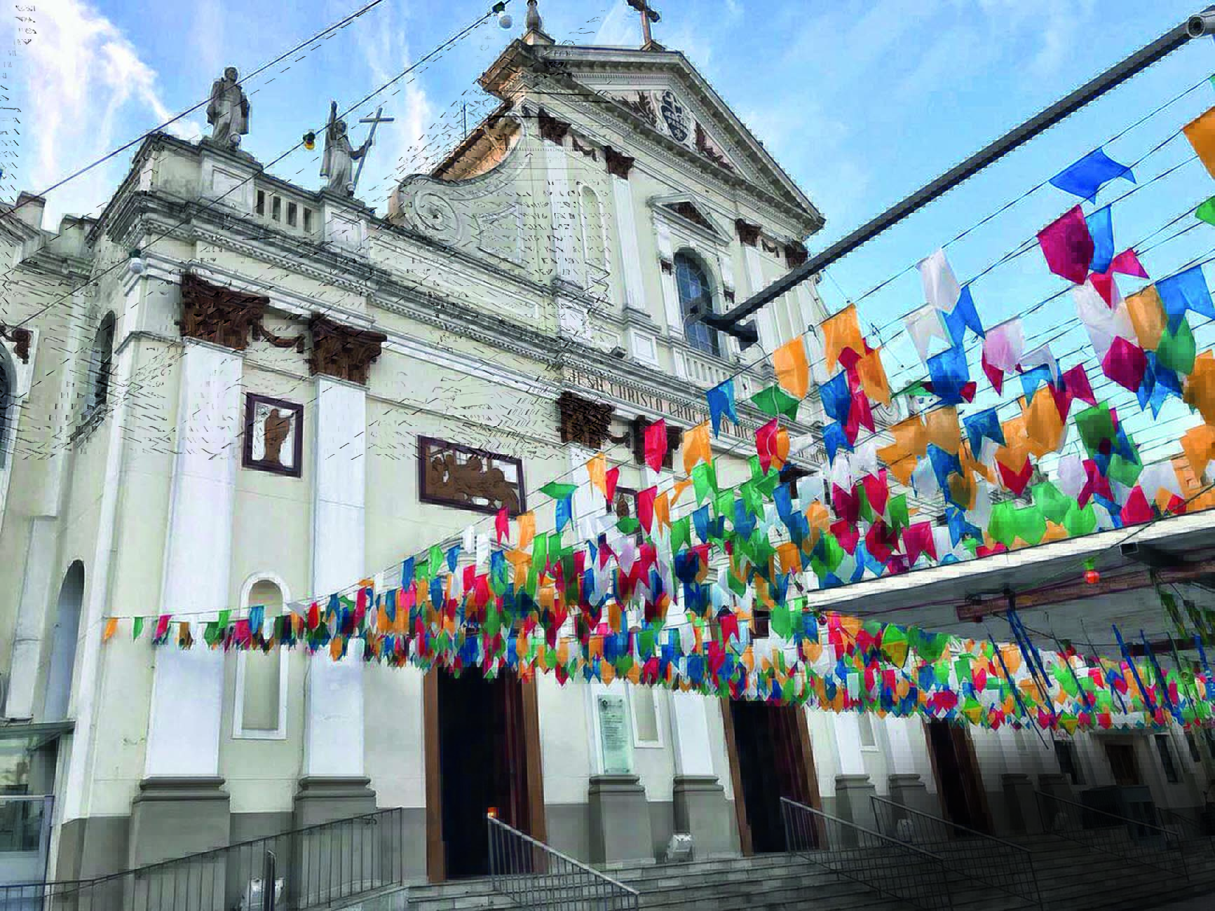 Imagem mostra frente de igreja com bandeirinhas de São João penduradas