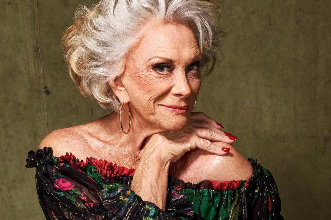 Mulher idosa com a mão direita no queixo