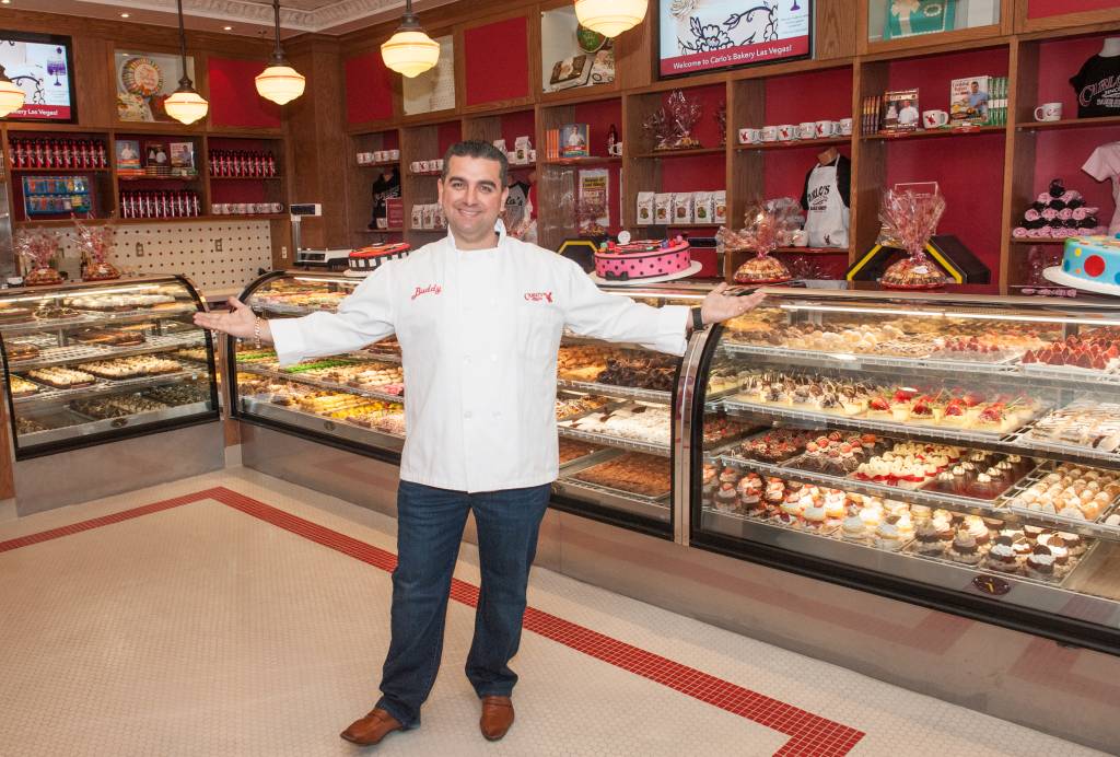 Buddy Valastro posa de braços abertos em uma das unidades de sua confeitaria, a Carlo's Bakery