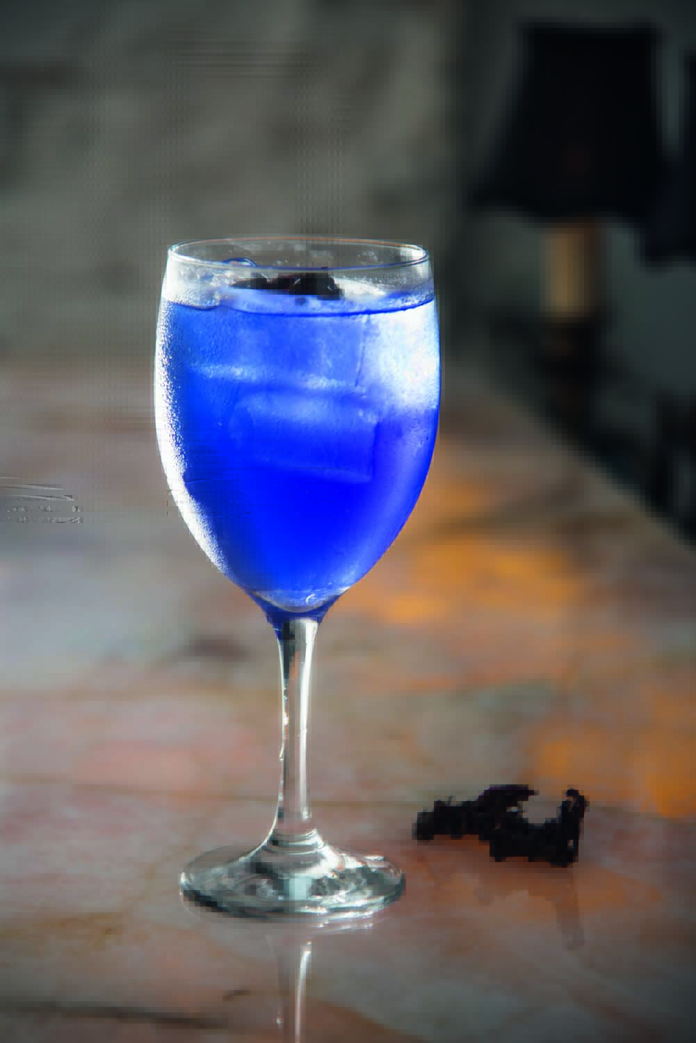 Drinque de cor azulada servido em taça alta