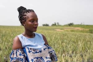 A chef africana Fatmata Binta diante de um campo cultivado