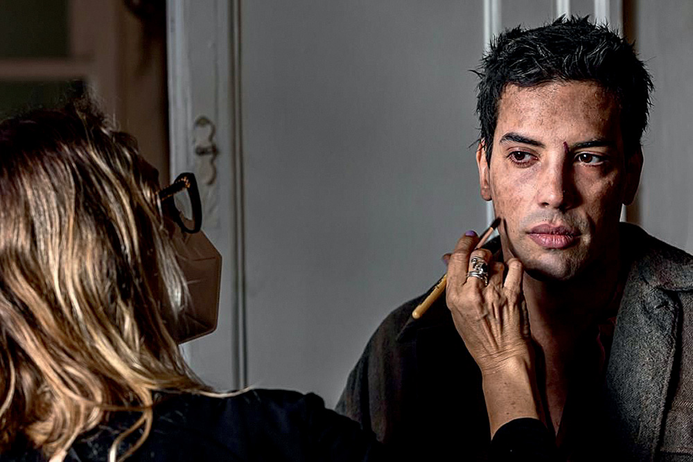 Felipe de Carolis sendo maquiado em bastidores de filme.
