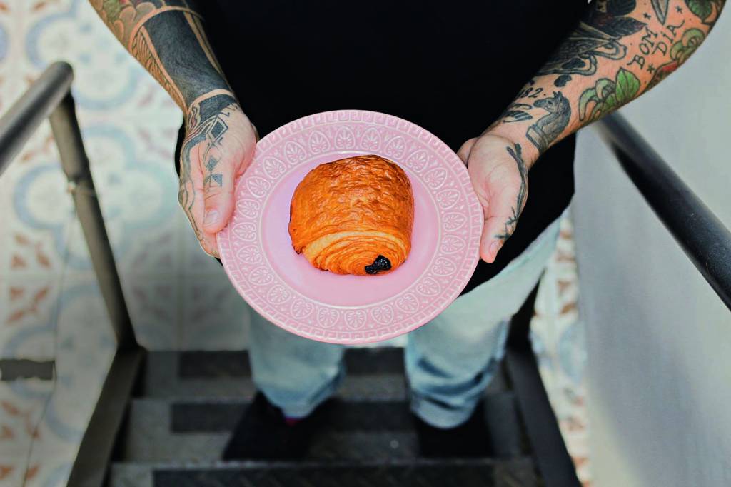 Over Coffee Roasters Pain au chocolat servido sobre pequeno prato raso de cor rosa