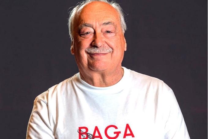 Luis Pato posa com camiseta branca estampada com frase escrita em letras vermelhas enquanto segura garrafa de vinho