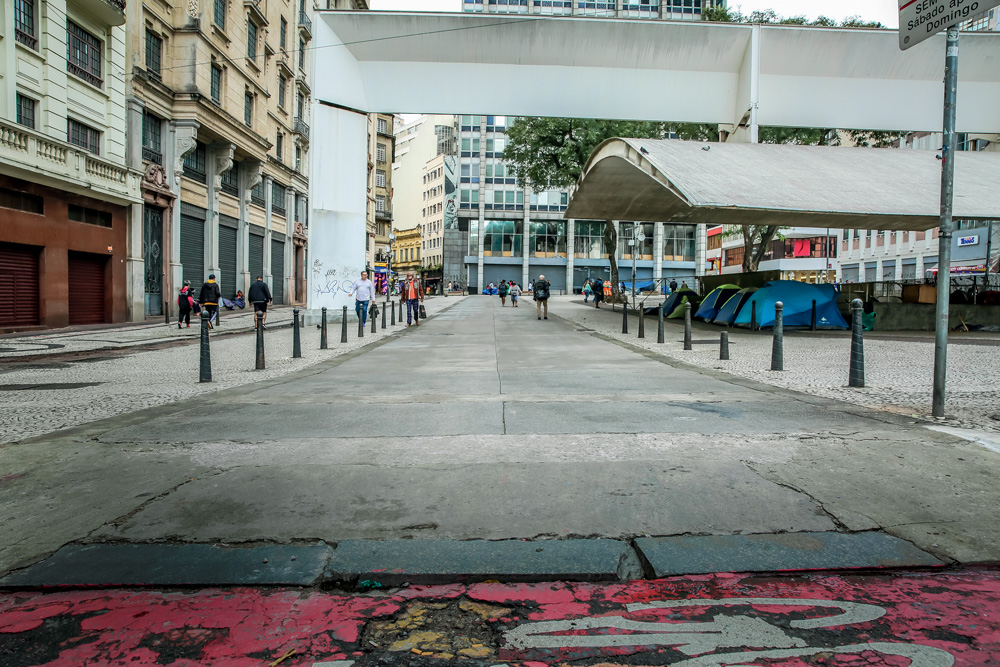 Imagem mostra calçada esburacada em praça