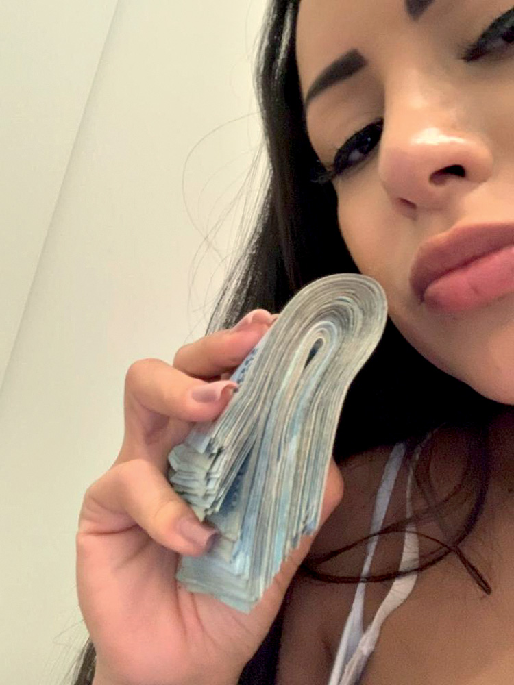 Imagem mostra mulher com maço de dinheiro nas mãos