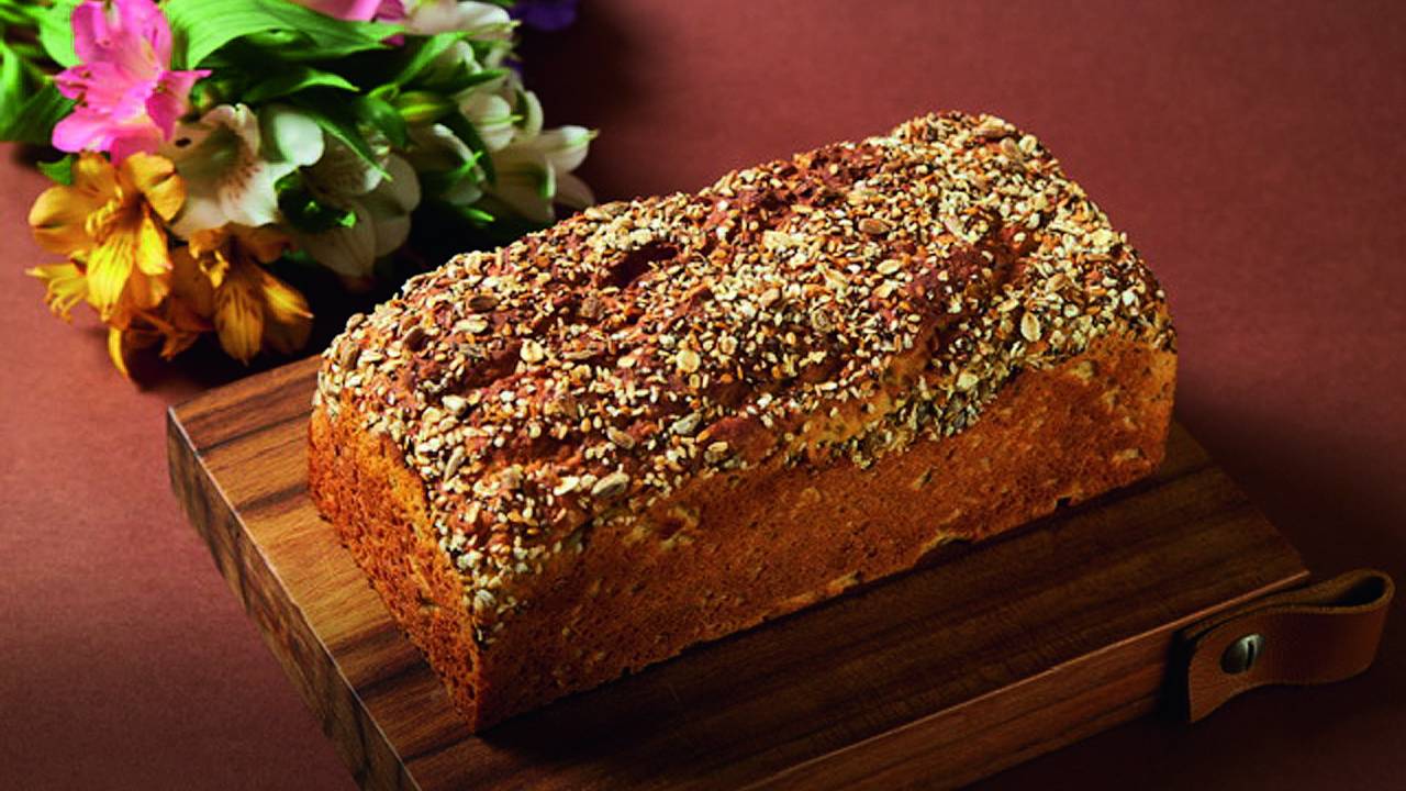 Pão multigrãos servido em tábua de madeira