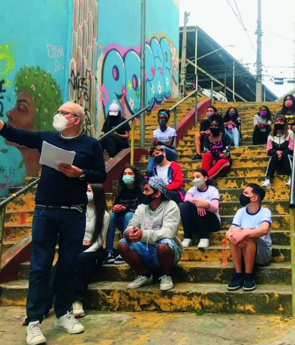 Paulo Magalhães tira selfie com seus alunos em aula na rua
