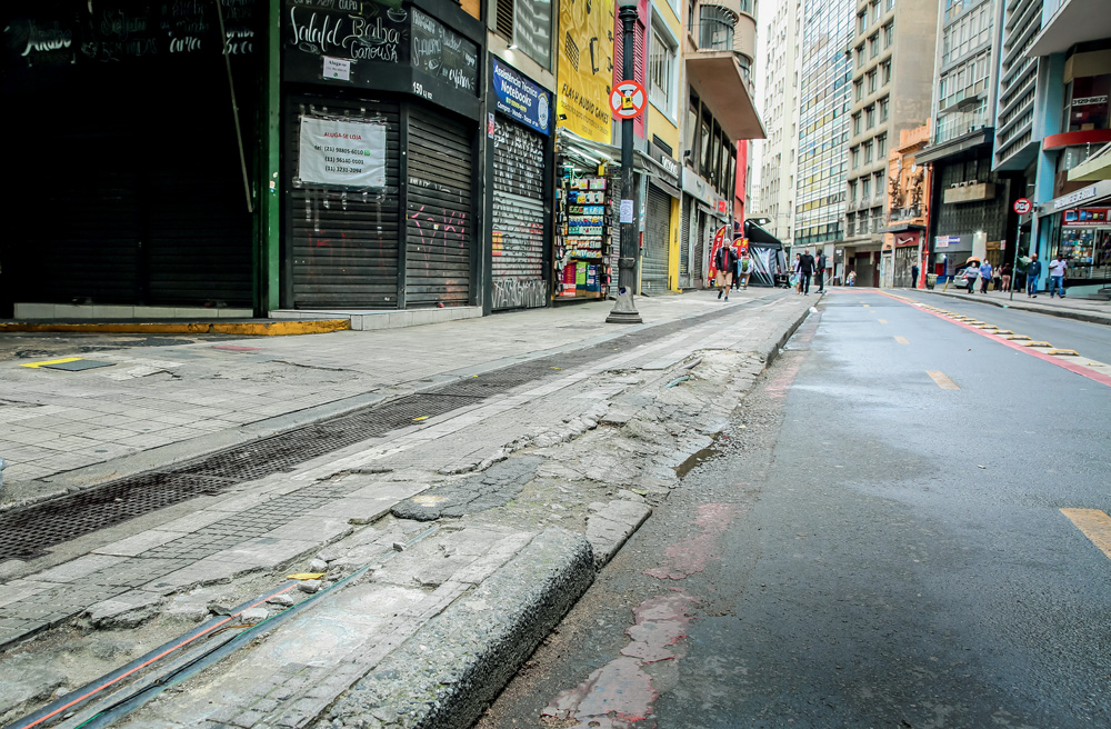 Imagem mostra guia de rua esburacada.